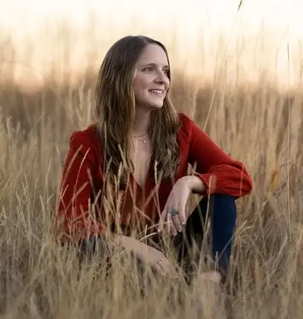 Tricia Corso, LCSW sitting in grass field